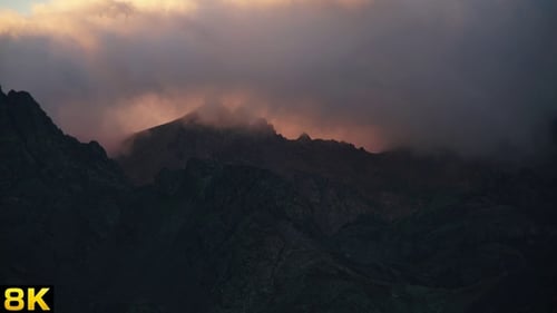 Mountains shrouded in clouds at sunset