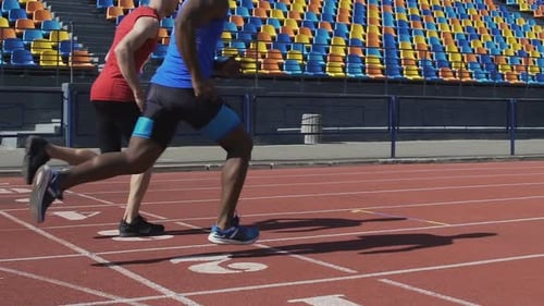 Sportsmen of athletic team training, running on sports field, marathon race