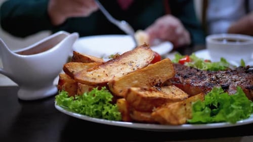 Steak on Ribs with Potatoes and Salad on a Table in a Georgian Restaurant