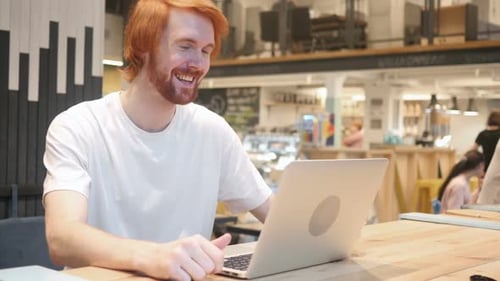 Video Chat in Cafe on Laptop By Young Man Talking with Customers