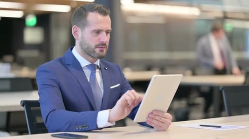 Frustrated Businessman Reacting to Tablet in Office