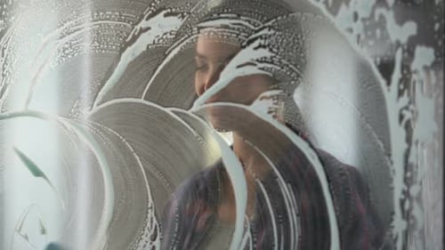Lady Washing Windows and Removing Stains Using Special Substances and Tools