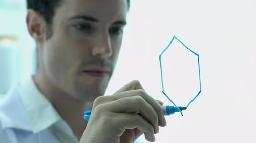 Scientist writing molecular formula on glass wall