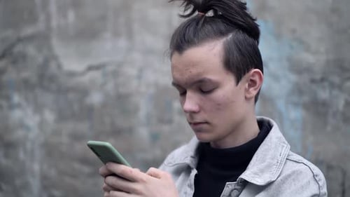 Young Teenager Reads Messages on His Phone