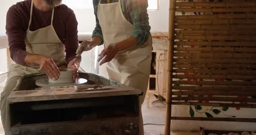 Un potier aide une potière