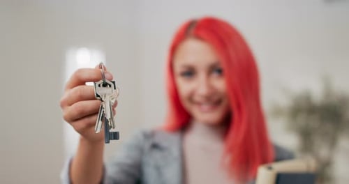 Shot of Apartment Keys Extended on Hand Toward Camera Pinkhaired Woman Dressed in Suit Holds