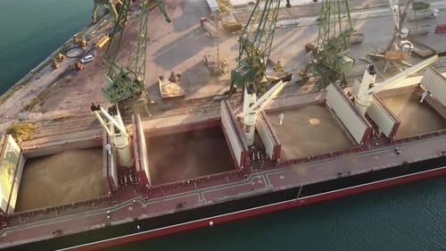 Aerial View of Big Cargo Ship Bulk Carrier is Loaded with Grain of Wheat in Port at Sunset