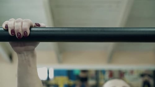 Joven atleta que hace ejercicio en el gimnasio se detiene en la barra Closeup 2