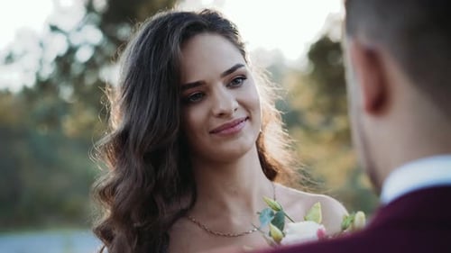 Happy Bride Holding Flowers Gazing at Groom