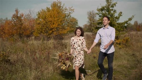Young Couple Walking on a Meadow