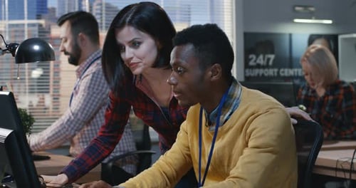 Two Colleagues Collaborating at Computer in Modern Office