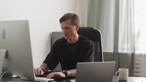 Programmierer streckt sich am Schreibtisch