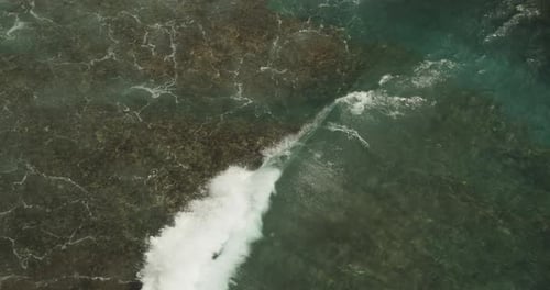Close Up Slow Motion View of a Shallow Wave Moving on the Water and Crashing Ashore the Rocky