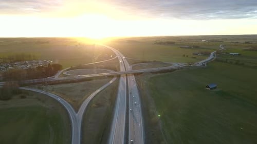 Aerial view of freeway intersection with moving traffic cars.
