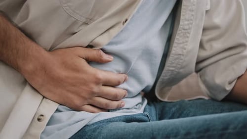 Closeup Unrecognizable Man Feels Pain in Stomach Bend Over Male Hands Holding Belly By Side Bad