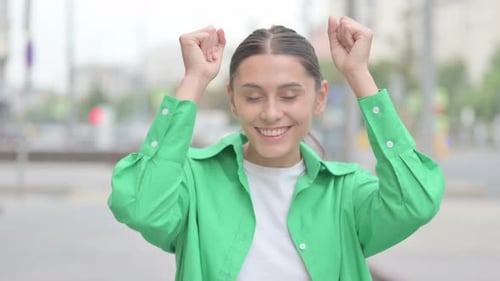 Young Woman Celebrates Success in Urban Environment