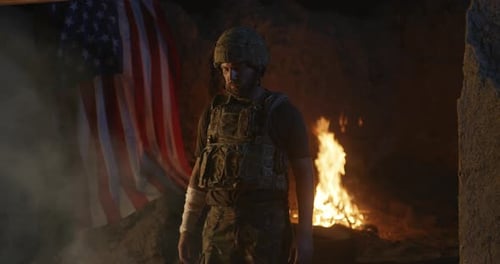 Soldier Standing Guard by Fire with American Flag