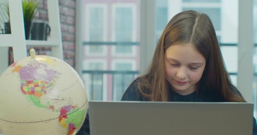 Little Child Girl Using Laptop for Doing School Tasks at Home and Writing Notes