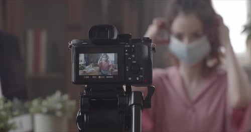 Woman Puts On Face Mask for Video Recording
