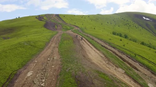 Motocross Racers Going Up the Steep Hill