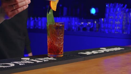 Cocktail Preparation at Bar with Orange Slice Garnish