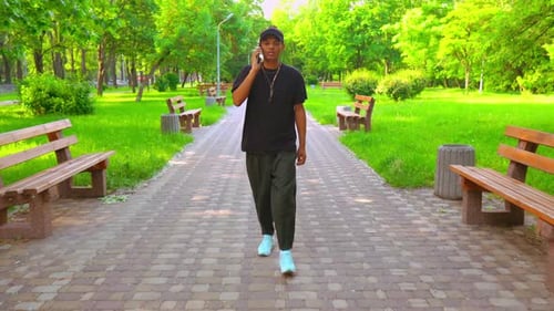 Man Walks and Talks on Phone in Green Park