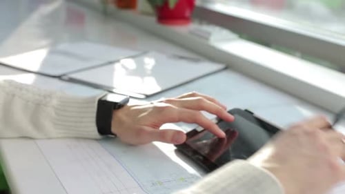 The business team works with construction drawings using a tablet.