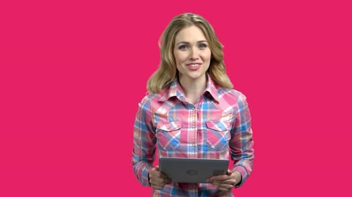 Woman Talking and Using Tablet on Pink Background