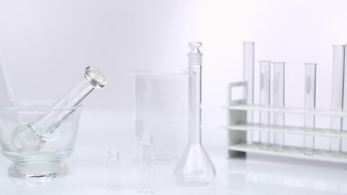 Panning view of beakers and glassware on white screen