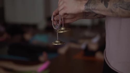 Unrecognizable Tattoo Man Holdsin His Hands a Pair of Bronze Karatal on a Rope Close Up