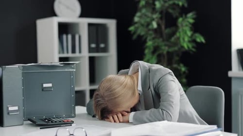 Business Woman Sitting at Desk in Office