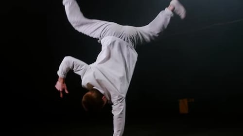 Young Man Dancer Spinning Aroung on One Hand and Keeping the Balance