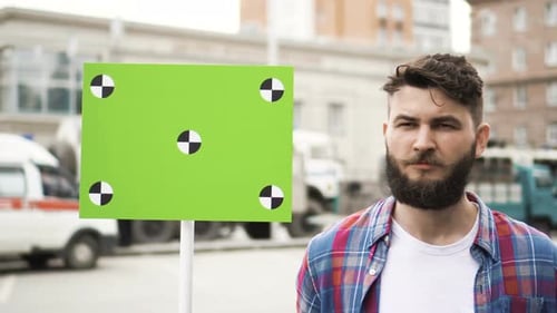 Man Next to Green Screen in City