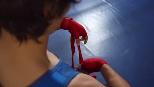 Mixed race man wrapping hands at gym