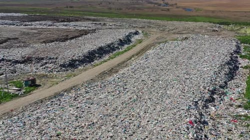 Expansive Landfill with Dirt Road and Waterway