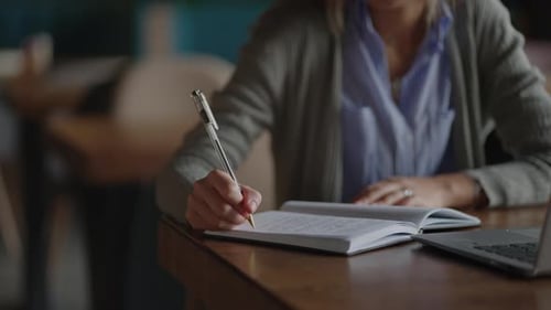 Closeup Pen Writes a Lecture in a Notebook Notebook