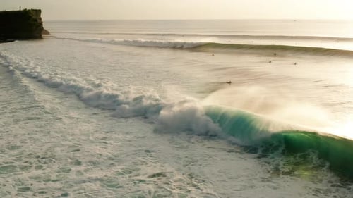 Golden Sunrise Waves Crashing on Beach with Surfers