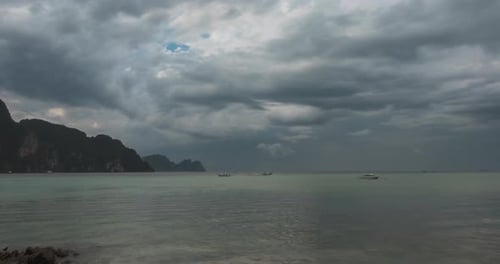 Zeitraffer von Regenwolken über Strand und Meereslandschaft mit Booten