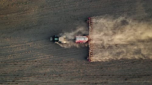 Landwirtschaftlicher Traktor mit spezieller Anhängerausrüstung bearbeitet das Land vor der Aussaat.