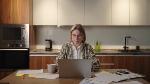 Young Adult Working on Laptop in Kitchen
