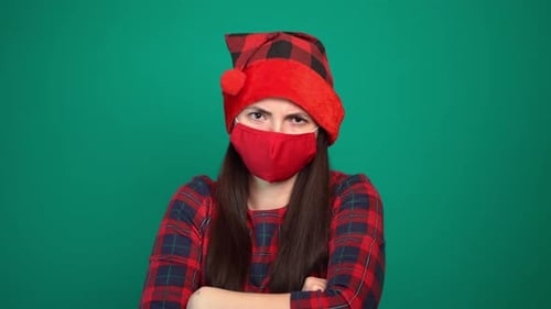 Woman in Mask and Christmas Hat with Crossed Arms