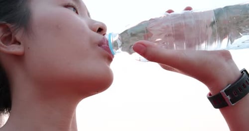 Young Woman Drinking Water Close-up Outdoors