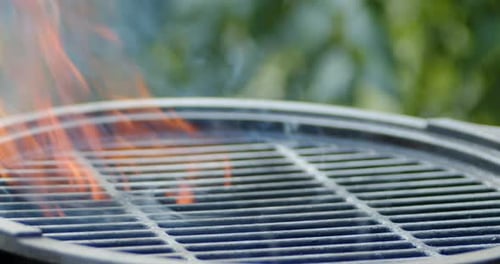 Grill mit Flammenzungen und Rauch.