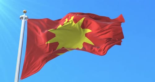 Red Flag with Yellow Sun Waving Against Blue Sky