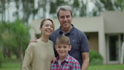 Happy Family Poses Together in Front of Home