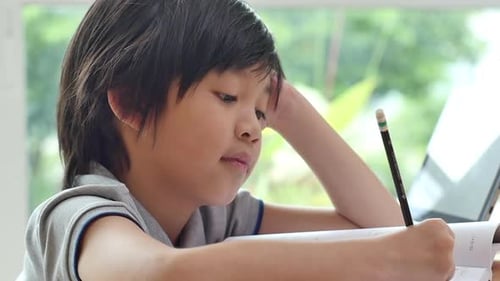 Asian Child Tired And Bored Of Doing Homework, Kid Stressed From Learning
