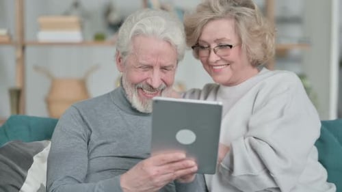 Senior Couple Enjoying Tablet Together at Home