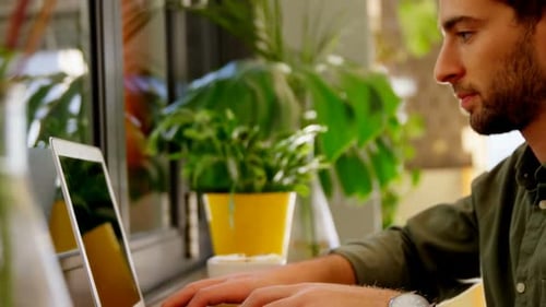 Nahaufnahme eines gutaussehenden Mannes mit Laptop am Tisch 4k