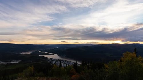 Time Lapse, View of Dawson City Lights from above at Sunset. Aerial Drone Shot. Taken from Midnight Dome Viewpoint, Yukon, Canada, Pan Down