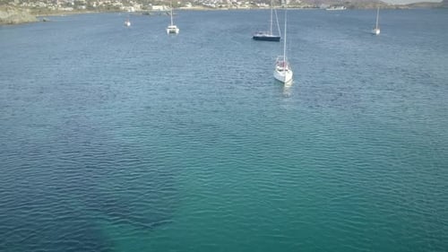 Aerial view of sailboats sailing cross blue and clean sea in Greece.
